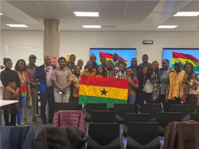 Group of people holding the Ghanaian flag